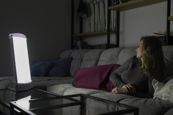 Kobieta z depresją jesienno zimową używa lampę Fotovita firmy Ultraviol